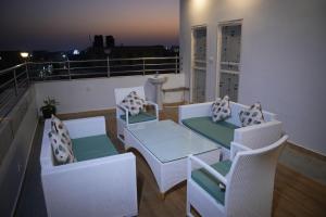 Un balcón con sillas y mesas. en Hotel Mystic Mithila en Janakpur