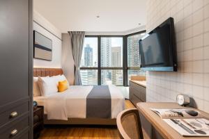 um quarto de hotel com uma cama e uma televisão de ecrã plano em Dash Living on Hollywood em Hong Kong