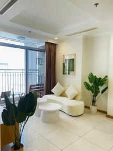 un soggiorno con divano bianco e una grande finestra di Vinhomes Landmark Apartment - CirillaHome ad Ho Chi Minh