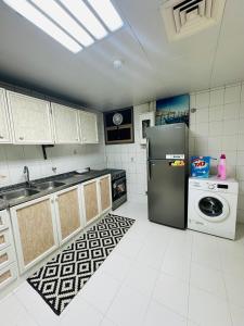 a kitchen with a refrigerator and a washing machine at Sunrise Inn by DSV Property in Abu Dhabi