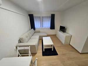 Sala de estar blanca con sofá y mesa en Nébel Vendégház Családi, en Komárom