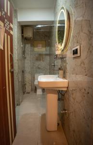 uma casa de banho com um lavatório e um espelho em Darjeeling Guest House Deluxe em Darjeeling