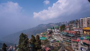 un groupe de bâtiments au sommet d'une montagne dans l'établissement Darjeeling Guest House Deluxe, à Darjeeling