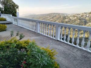 a white railing on a balcony with a view at Two Rooms- Mountain View Apartment with Wi-Fi in Kohīma
