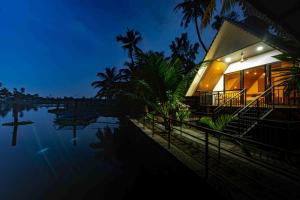 a house by the water at night at Liara Fish Net Villa in Elūr