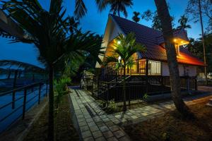 a house on the beach at night with palm trees at Liara Fish Net Villa in Elūr
