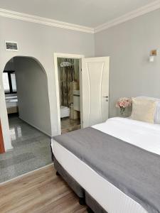 a white bedroom with a bed and a hallway at Antik Ipek Hotel in Istanbul