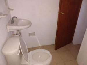 a small bathroom with a toilet and a sink at LOS ALAMOS in San Cristóbal de Las Casas