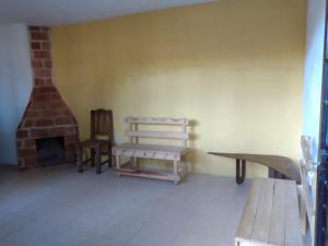 a room with a fireplace and a bench and a chair at LOS ALAMOS in San Cristóbal de Las Casas