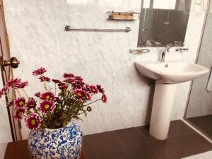 a bathroom with a sink and a vase with flowers at Fox Kandy in Kandy