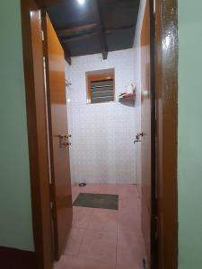 a bathroom with a shower with a tiled floor at Hallimane Homestay in Udupi