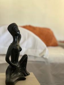 une figurine noire d'une personne assise sur une table dans l'établissement Bungalow Ballena c/vistas increíbles al Océano Pacífico, à Perihuete