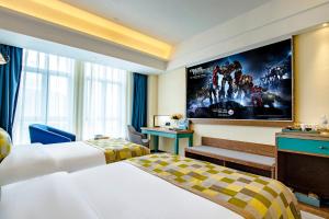 a hotel room with two beds and a movie on the wall at Mehood Theater Hotel, Lhasa in Lhasa