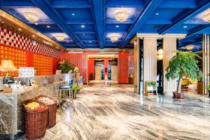 拉薩的住宿－美豪酒店拉萨店，大堂设有红色的墙壁和蓝色的天花板。