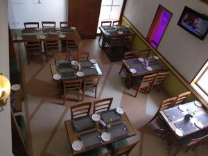 uitzicht op een restaurant met tafels en stoelen bij Hotel Western Gatz in Theni