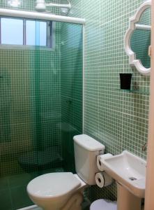 Baño de azulejos verdes con aseo y lavamanos en Pouso do Sopé, en Paraty