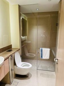 a bathroom with a toilet and a glass shower at Luxurious Apartment in Dubai