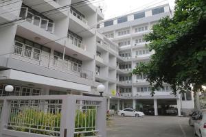 a white building with cars parked in front of it at Khelang Nakorn Hotel in Lampang