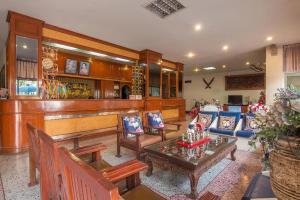 a living room with a bar with a table and chairs at Khelang Nakorn Hotel in Lampang