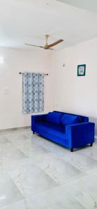 um sofá azul num quarto branco com tecto em Apartment near LNT & CTC & Airport - 3F em Chennai