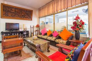 a living room with a couch and a tv at Khelang Nakorn Hotel in Lampang