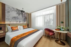een slaapkamer met een groot bed en een rode stoel bij 琴笙酒店 in Xiamen