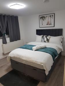 a bedroom with a large bed with a black headboard at Holiday Let - Entire modern home in Medway in Gillingham