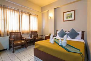 a hotel room with a bed and a dining room at Khelang Nakorn Hotel in Lampang