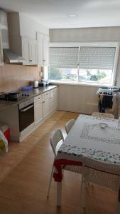 a kitchen with a table and chairs and a kitchen with a window at H5J - APT in Vila Nova de Gaia