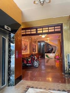 Hoàng Gia Hotel - 1224 CMT8 Bình Dương - by Bay Luxury في Ấp Phú Thọ: غرفة معيشة مع دراجة نارية متوقفة في غرفة