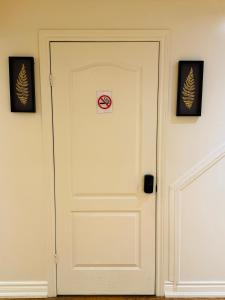 Scotchmere Serenity: Modern 1-Bedroom Brampton Haven في برامبتون: باب أبيض عليه لافتة ممنوع التدخين
