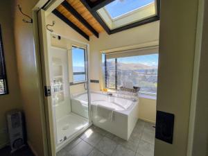uma casa de banho com um lavatório, um chuveiro e uma janela. em TekapoB2 Lakeview Apartment em Lake Tekapo