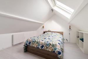 1 dormitorio con 1 cama en una habitación blanca en maison proche Disneyland , parc des Félins et Coulommiers, en Saint-Augustin