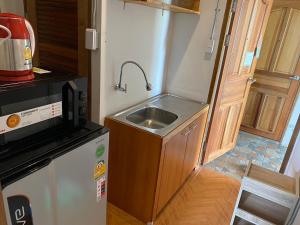 a small kitchen with a sink and a refrigerator at Fuji Hotel in Chiang Mai