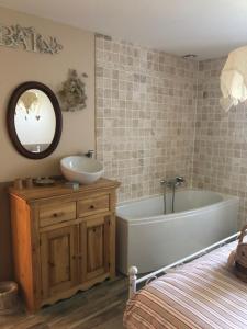 a bathroom with a tub and a sink and a mirror at Chambres d'hôtes d'Albertine in Lere