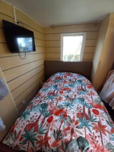 Un dormitorio con una cama con una colcha floral. en Mobilhome EUROPA PARK, en Boofzheim