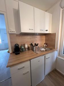 a kitchen with white cabinets and a sink at Studio le Cerisier in Troyes