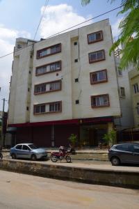 un bâtiment avec une moto garée devant lui dans l'établissement Royalwood Deluxe, à Bangalore