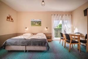 a bedroom with a bed and a table and chairs at Granada Pensjonat & SPA in Duszniki Zdrój