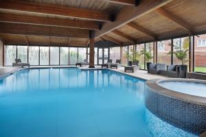 a large swimming pool in a hotel with chairs at Delta Hotels by Marriott Preston in Preston