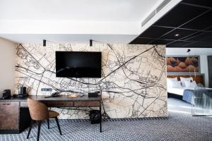 a wall mural with a desk and a tv at Hotel M23 Katowice in Katowice