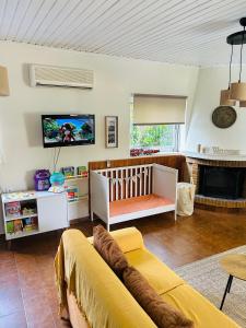 salon z kanapą i łóżeczkiem dziecięcym w obiekcie Grandpa’s cottage w mieście Nea Makri