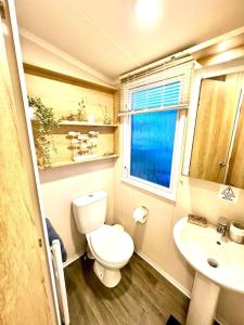 a small bathroom with a toilet and a sink at The Beach Retreat in Par