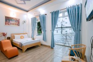 Schlafzimmer mit blauen Vorhängen, einem Bett und einem Fenster in der Unterkunft Calido Hotel Vung Tau in Xã Thang Tam