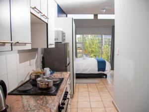 una cucina con piano cottura e un letto in una camera di Leas Furnished Apartments - Capital Hill a Pretoria