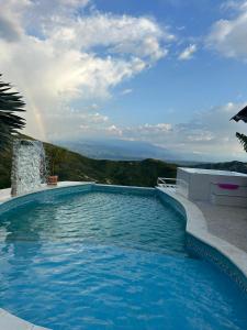 ein großer Pool mit Regenbogen im Hintergrund in der Unterkunft Lago Calima-Villa la Estrella in Yotoco