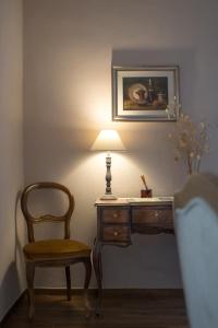 einen Schreibtisch mit einem Stuhl und einer Lampe in einem Zimmer in der Unterkunft Casa Cantagalli in Tavarnuzze