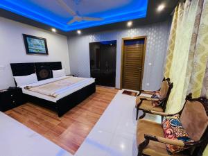 - une chambre avec un lit et un plafond bleu dans l'établissement Imperial Lodges, à Islamabad