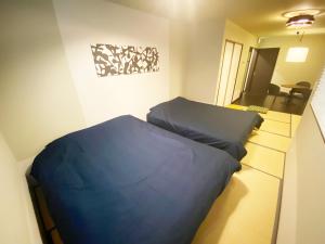京都市にあるKAMON INN AIHUKAのベッドルーム1室(青いベッド1台付)