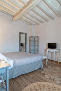 ein Schlafzimmer mit einem großen Bett und einem TV in der Unterkunft Casa Cantagalli in Tavarnuzze